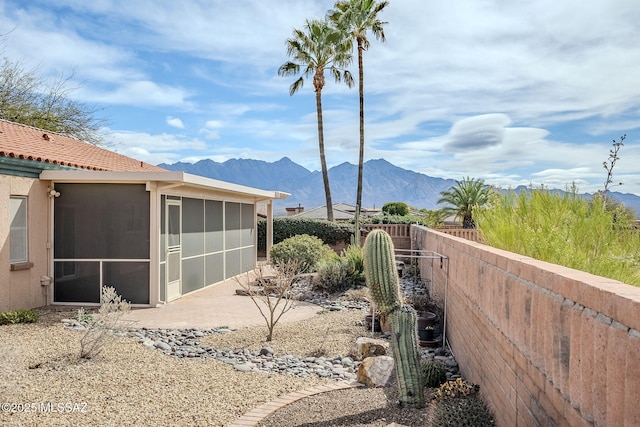 exterior space with a mountain view, a patio area, and a sunroom