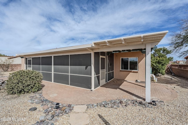 back of house featuring a sunroom and a patio