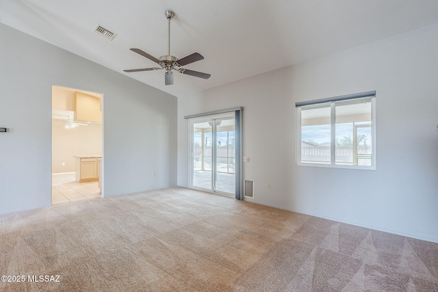 carpeted spare room featuring ceiling fan and vaulted ceiling