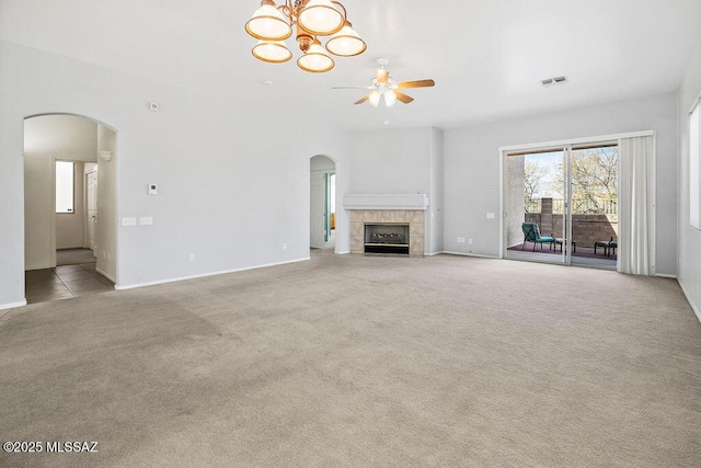 unfurnished living room featuring light colored carpet, a tile fireplace, and ceiling fan