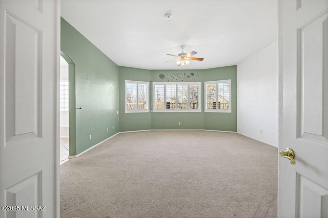 carpeted spare room with ceiling fan