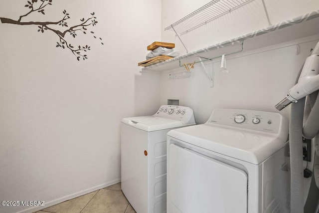 clothes washing area with washing machine and clothes dryer and light tile patterned floors