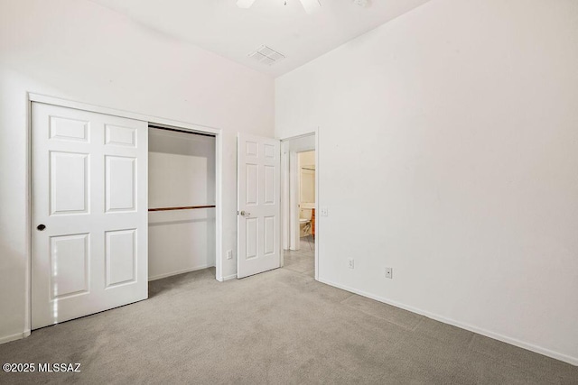 unfurnished bedroom featuring light colored carpet and a closet