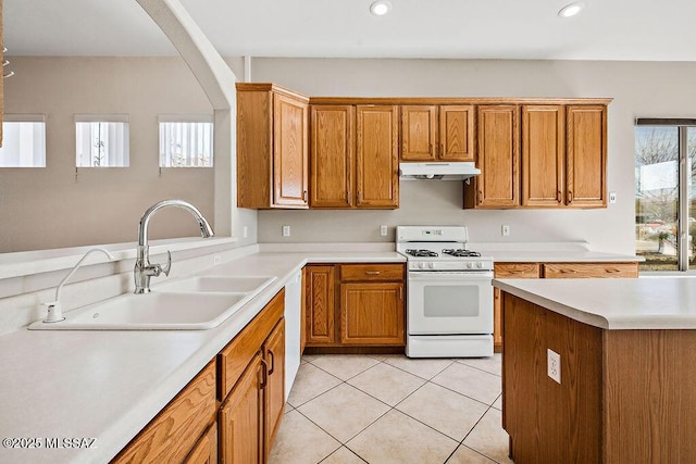 kitchen with light tile patterned flooring, a healthy amount of sunlight, white range with gas cooktop, and sink