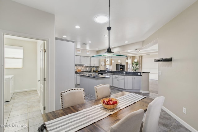 dining room with independent washer and dryer, sink, and light tile patterned floors