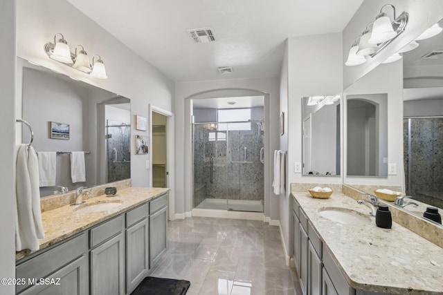 bathroom with a shower with door and vanity