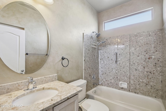 full bathroom with tiled shower / bath, vanity, and toilet