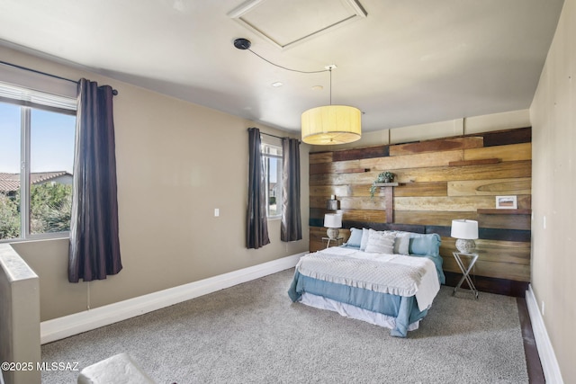 bedroom featuring carpet, multiple windows, and wood walls