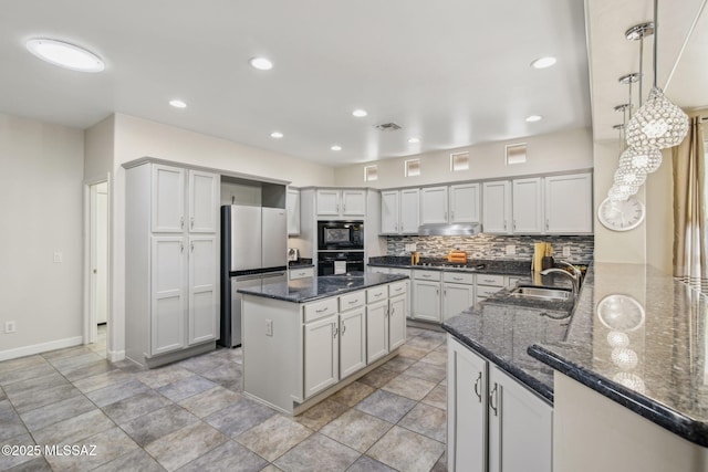 kitchen featuring kitchen peninsula, sink, decorative backsplash, hanging light fixtures, and black appliances