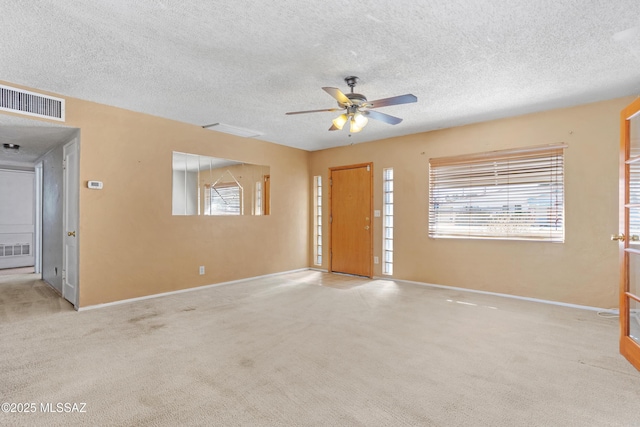 foyer entrance with a healthy amount of sunlight, visible vents, and carpet flooring