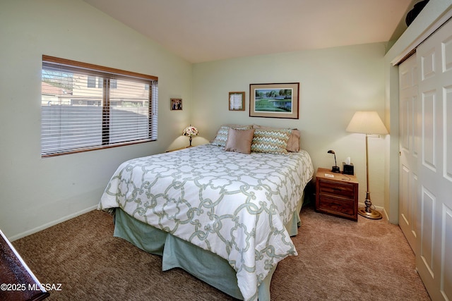 carpeted bedroom with lofted ceiling and a closet