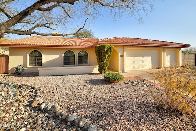 mediterranean / spanish-style home with a garage