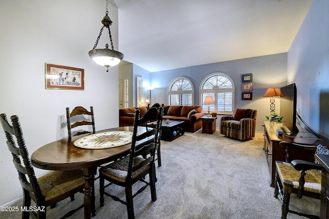 carpeted dining room featuring lofted ceiling