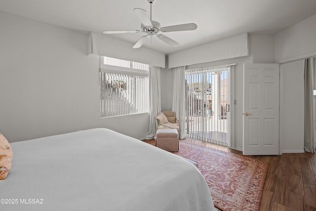 bedroom featuring access to exterior, dark wood-type flooring, and ceiling fan