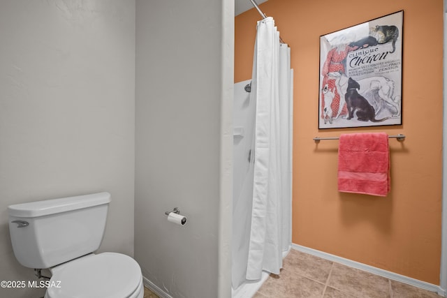 bathroom featuring tile patterned flooring, curtained shower, and toilet