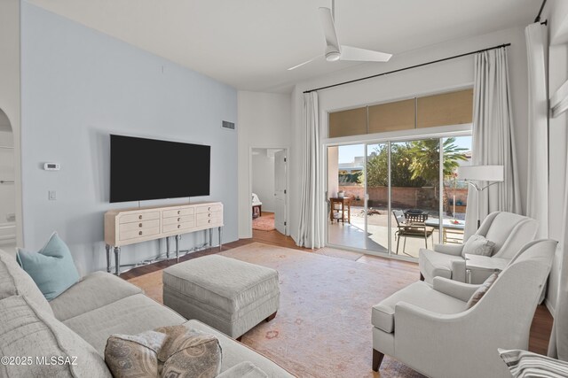 living room featuring ceiling fan with notable chandelier, lofted ceiling, and hardwood / wood-style floors