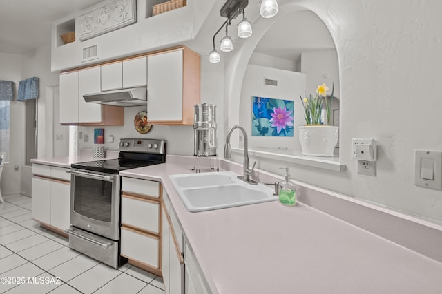 kitchen featuring light tile patterned floors, sink, stainless steel electric range, and white cabinets