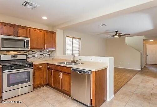 kitchen with stainless steel appliances, tasteful backsplash, sink, and light tile patterned floors