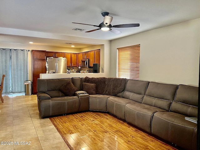 living room featuring ceiling fan and light hardwood / wood-style flooring