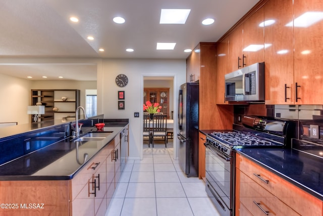 kitchen featuring sink, light tile patterned floors, and black appliances