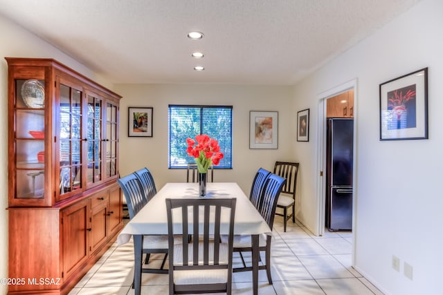 tiled dining space with a textured ceiling