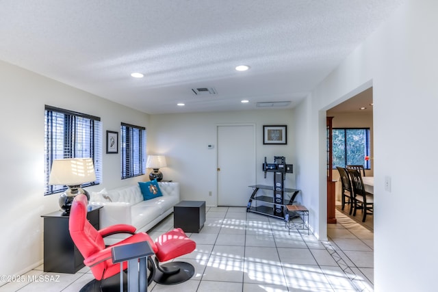 living room with a healthy amount of sunlight, a textured ceiling, and light tile patterned floors