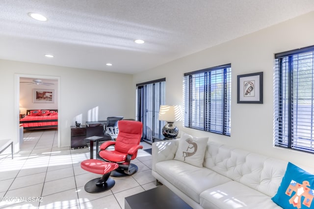 living room featuring a wealth of natural light, tile patterned floors, and a textured ceiling