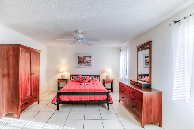 bedroom with ceiling fan, a textured ceiling, and light tile patterned flooring