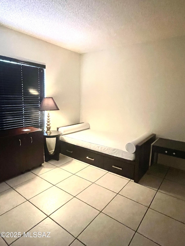 bedroom with a textured ceiling and light tile patterned floors