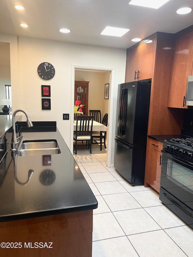 kitchen with sink, black appliances, and light tile patterned flooring