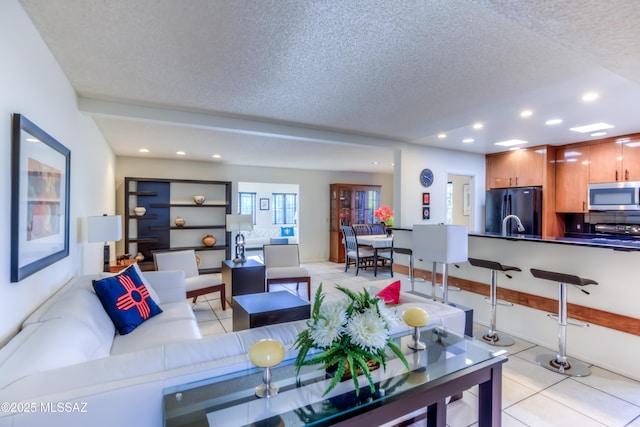 living room featuring a textured ceiling and light tile patterned floors