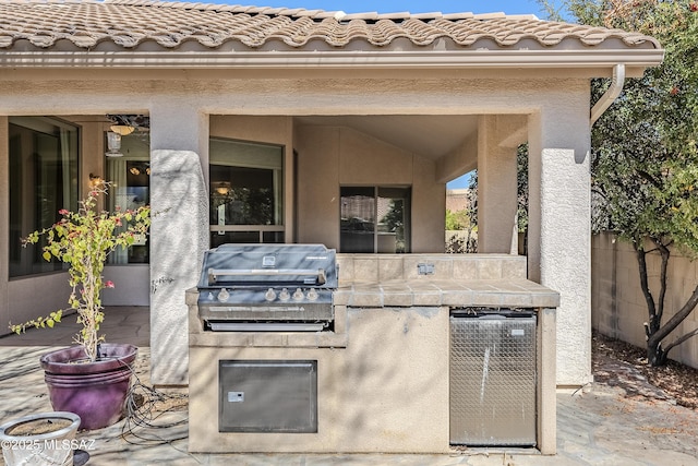 view of patio featuring area for grilling, a grill, and fence