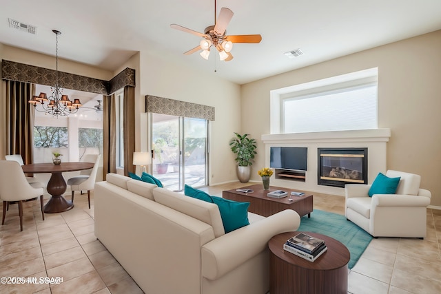 living area with light tile patterned floors, visible vents, and a glass covered fireplace