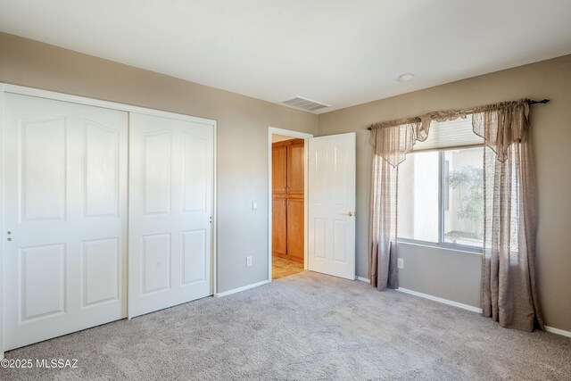 unfurnished bedroom with carpet, visible vents, a closet, and baseboards