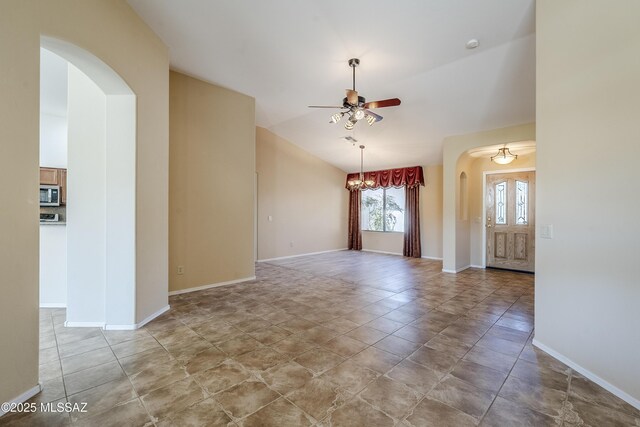 unfurnished room with ceiling fan with notable chandelier, arched walkways, and baseboards