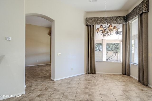 unfurnished dining area with visible vents, arched walkways, and baseboards