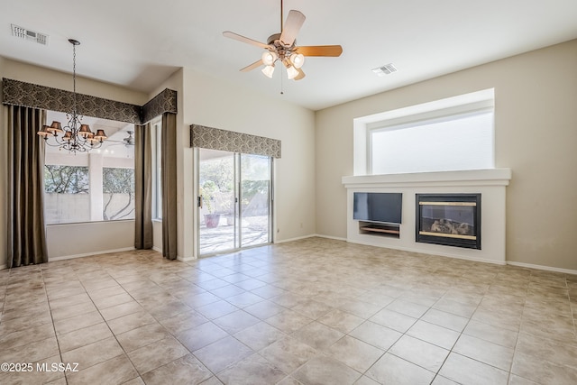 unfurnished living room featuring visible vents, baseboards, a glass covered fireplace, and ceiling fan with notable chandelier