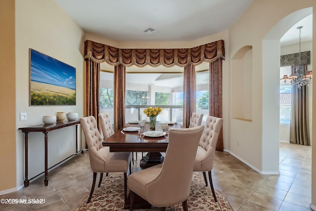 dining room featuring an inviting chandelier, light tile patterned floors, visible vents, and a wealth of natural light