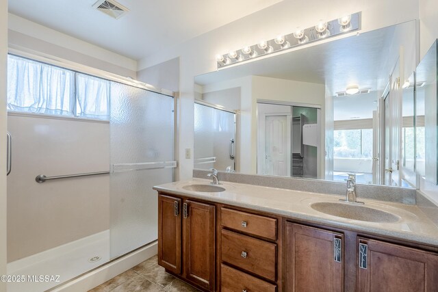 bathroom with a sink, visible vents, a shower stall, and tile patterned floors