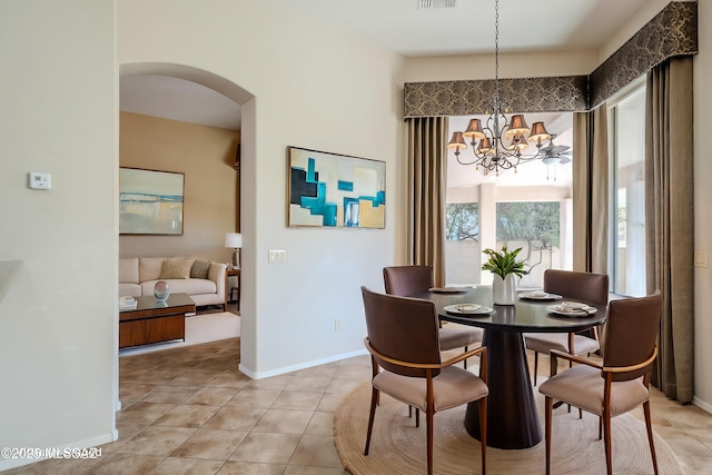 dining space featuring visible vents, arched walkways, light tile patterned flooring, baseboards, and a chandelier