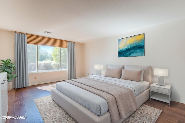 bedroom featuring visible vents, baseboards, and wood finished floors