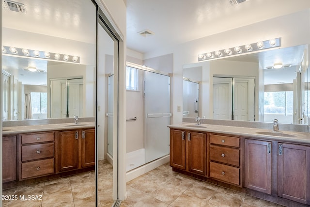 full bath featuring double vanity, visible vents, and a sink