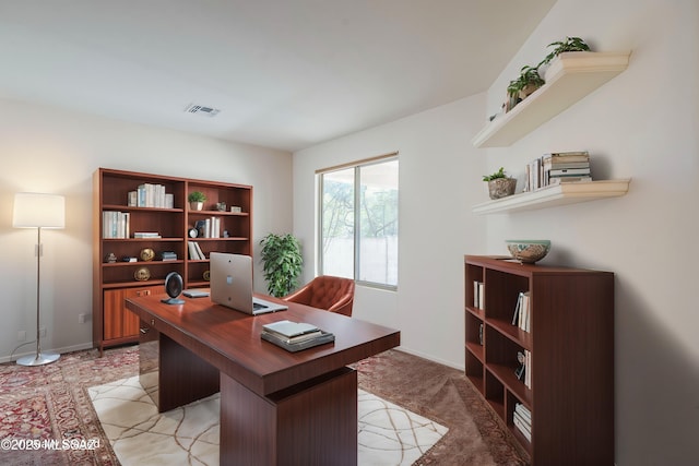 home office with visible vents, light colored carpet, and baseboards