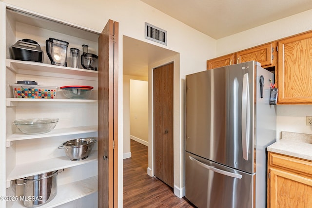 kitchen with dark hardwood / wood-style floors and stainless steel fridge