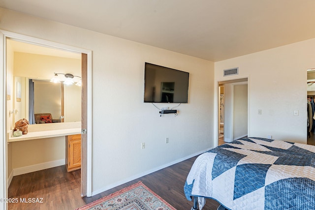 bedroom with ensuite bathroom and dark hardwood / wood-style flooring