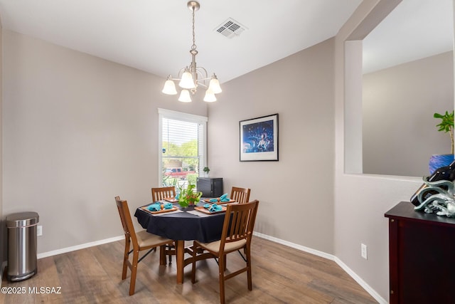 dining area featuring a notable chandelier and dark hardwood / wood-style flooring