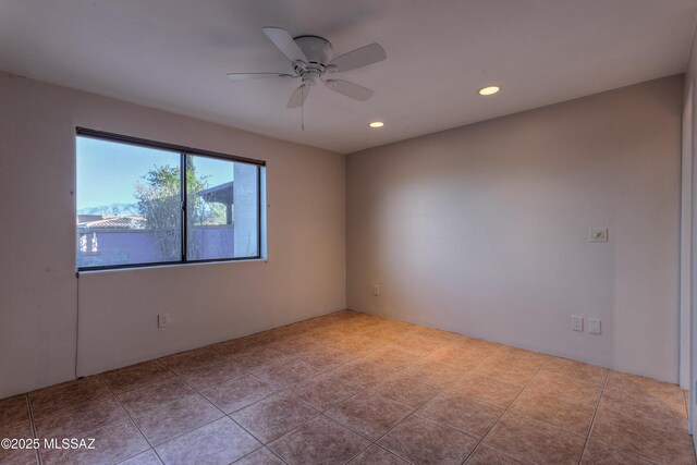 empty room featuring light tile patterned flooring and ceiling fan