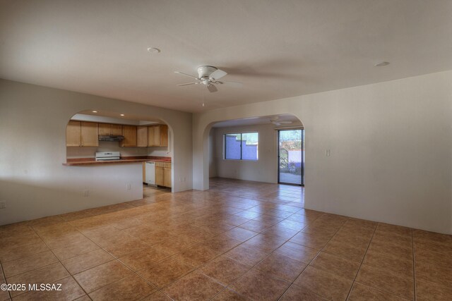 unfurnished living room with dark tile patterned floors and ceiling fan