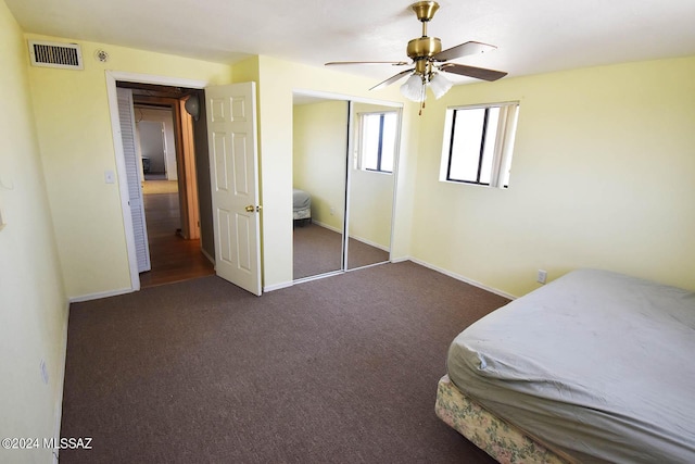 carpeted bedroom with ceiling fan and a closet