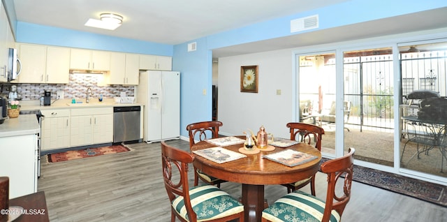 dining room featuring sink and light hardwood / wood-style floors